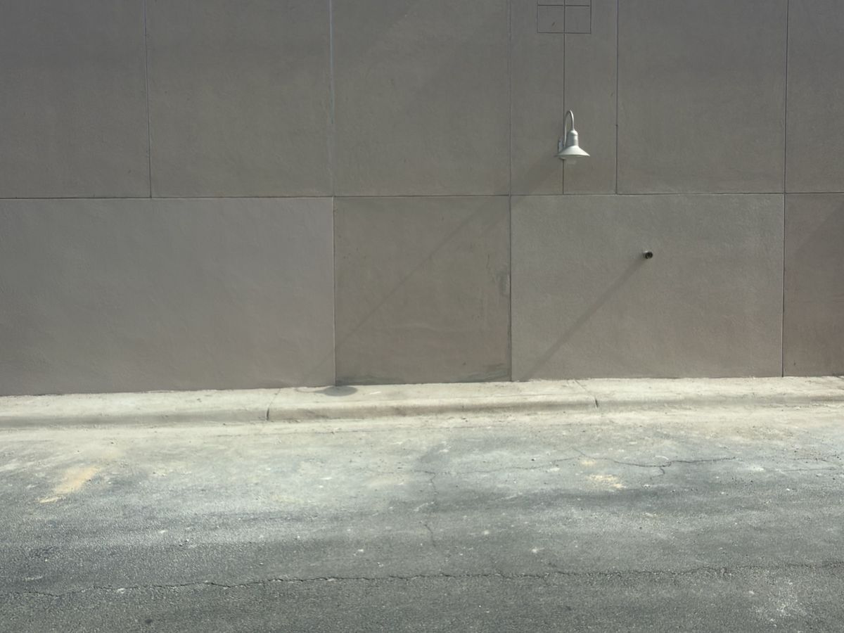 The same exterior wall rebuilt and re-stuccoed, with no visible sign of the repair