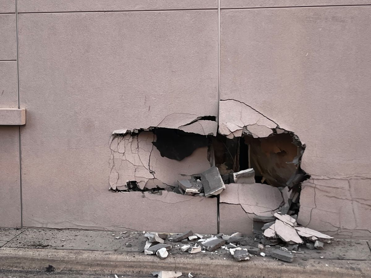 Hole punched through the exterior block and stucco wall by a vehicle