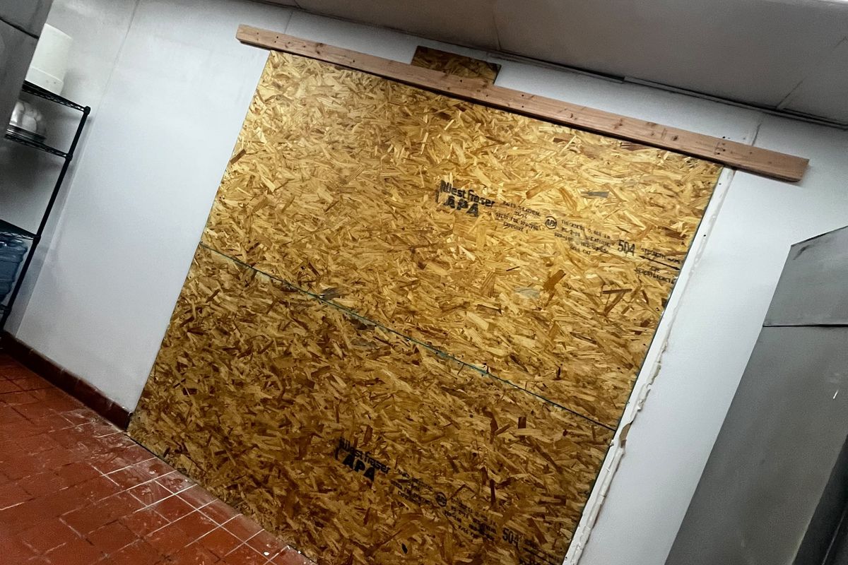 Opening boarded over with sheathing to secure the building